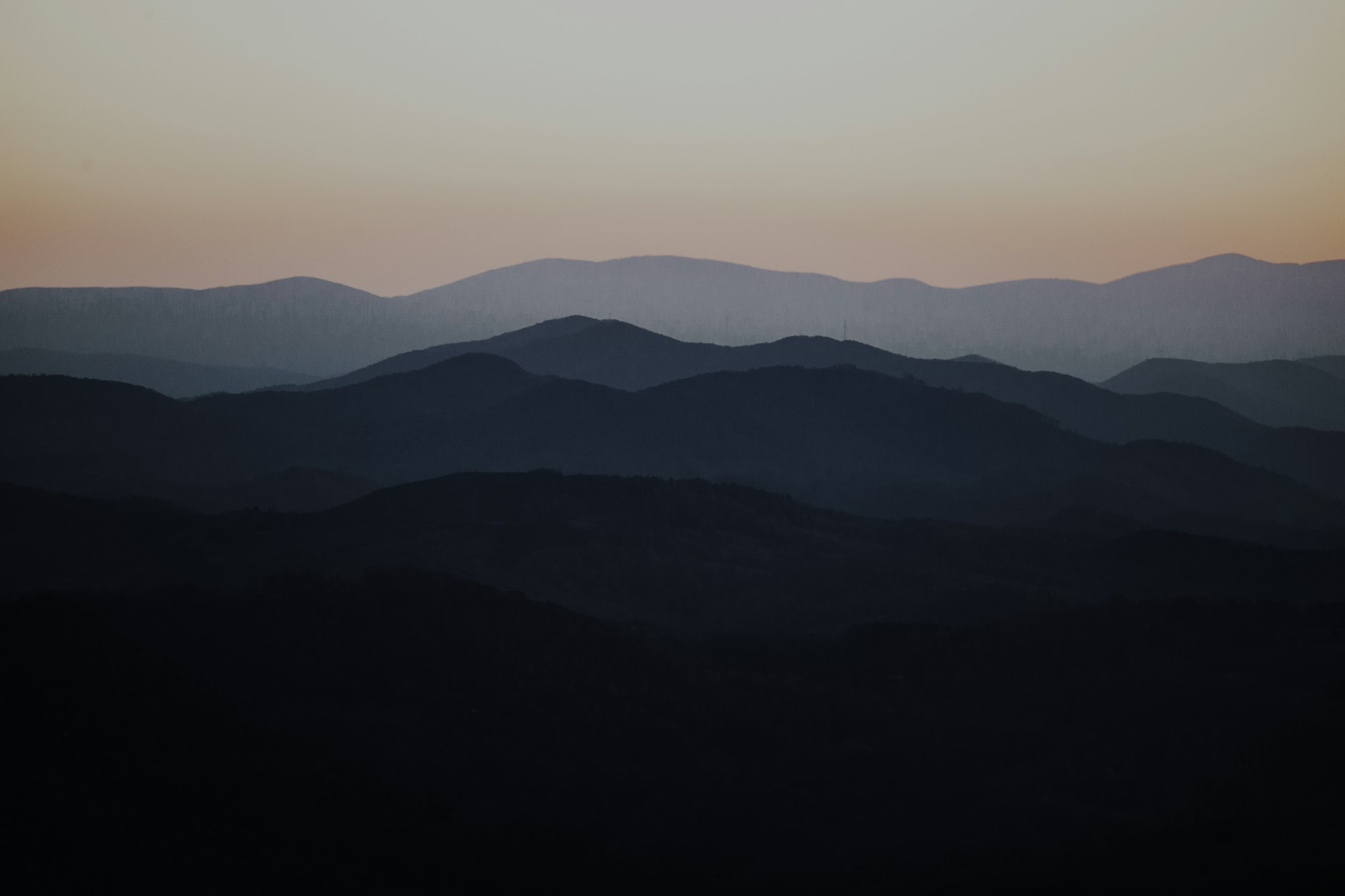 Soft, layered mountain ridges in calming dusk tones