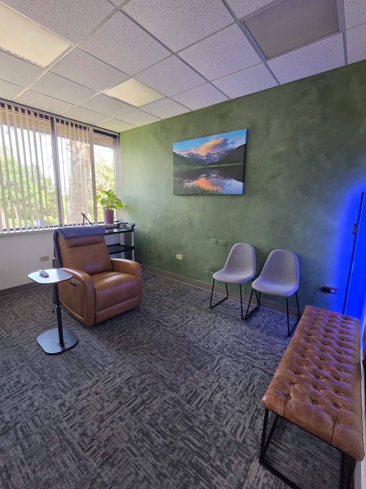 TMS treatment room with reclining leather chair and Colorado mountain artwork